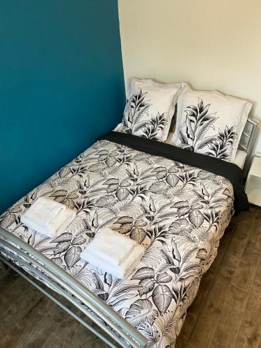 - un lit non aménagé dans une chambre dotée d'un mur bleu dans l'établissement Appartement moderne proche commerces, à Brest