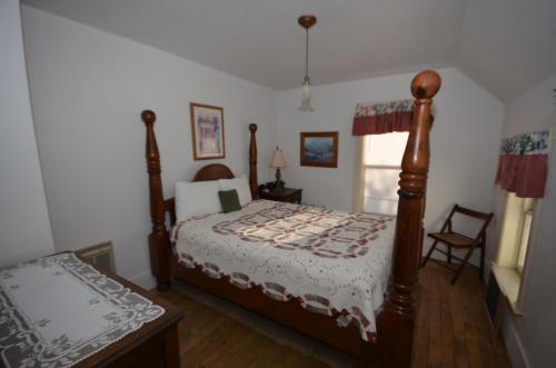 a bedroom with a bed and a chair in it at Somewhere In Time in Cedar