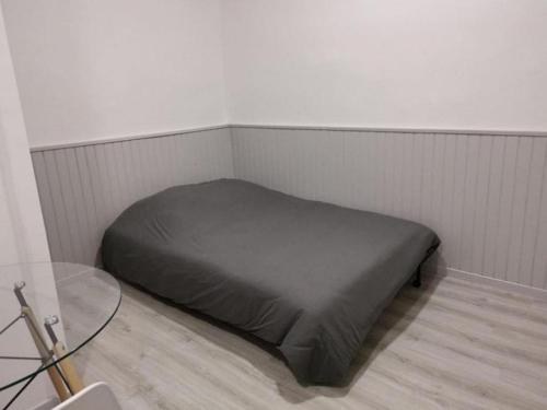 - un lit dans un coin d'une chambre avec une table en verre dans l'établissement Appartement T1 centre ville Carmes Metz, à Toulouse