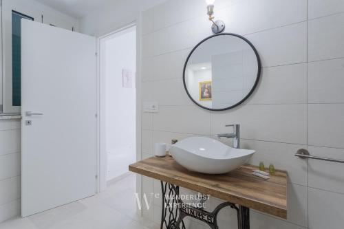 a bathroom with a white sink and a mirror at Wanderlust Experience Loggiato del duca in Bitonto
