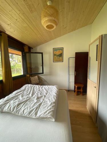 une chambre avec un lit blanc et une fenêtre dans l'établissement Appartement 4-6 pers - La Bourboule, à La Bourboule