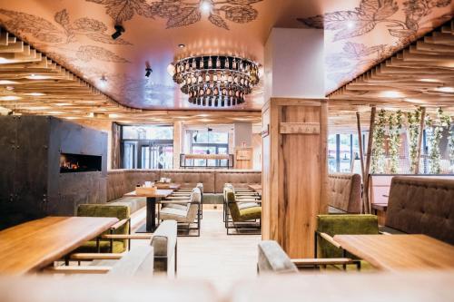 a restaurant with tables and chairs and a chandelier at AMIA Hotel Singen in Singen