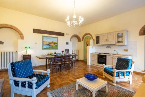 a kitchen and living room with a table and chairs at Borgo Badia by VacaVilla in Badia