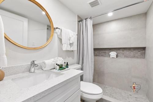 a bathroom with a sink and a toilet and a mirror at Bahia Mar Solare Beachfront Resort Condos with Two Pools in South Padre Island