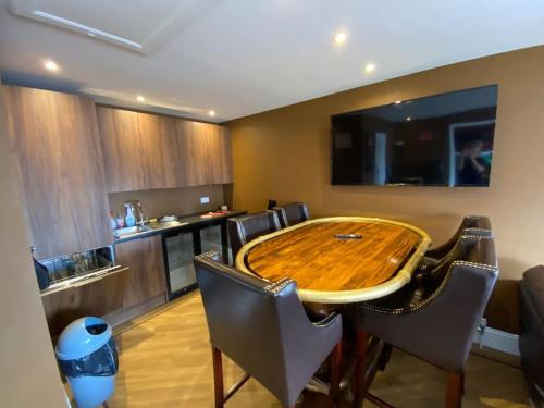 a kitchen with a wooden table and some chairs at The Bungalow at Parkside, 4 ensuite bedrooms in Goole