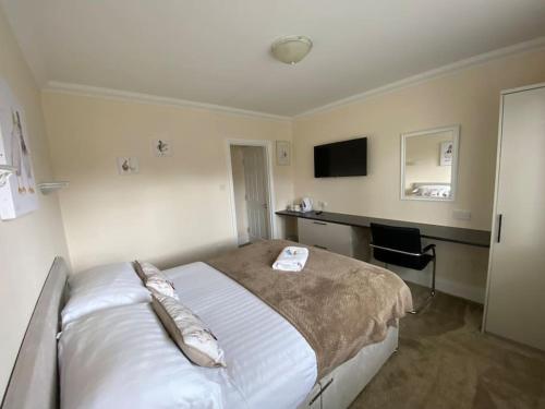 a hotel room with a bed and a desk at The Bungalow at Parkside, 4 ensuite bedrooms in Goole