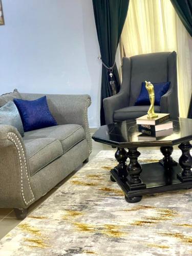 a living room with a couch and a coffee table at Wine House, Maitama, Abuja in Abuja
