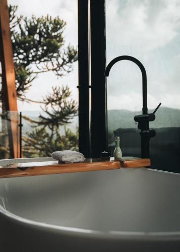 a kitchen counter with a sink and a window at Cabanas Terrunyo - Cabana Bela in Urubici
