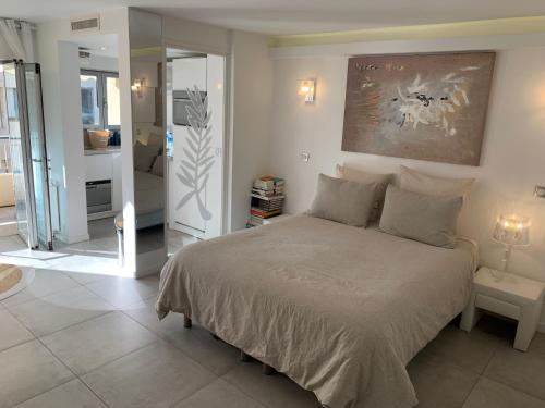 une chambre avec un lit avec un tableau sur le mur dans l'établissement Charmant studio Croisette, à Cannes