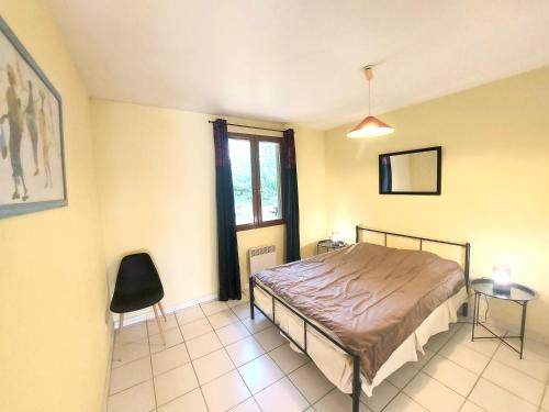 une chambre avec un lit, une fenêtre et une chaise dans l'établissement soleil catalan 50m2 rdc 2km mer ok chéques vacances animaux 4pers 3000m2 jardin wifi, à Elne