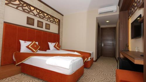 a hotel room with two beds and a television at Hotel Labella Bergama in Bergama