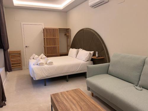 een slaapkamer met een bed, een bank en een stoel bij Corazón 23 in Córdoba