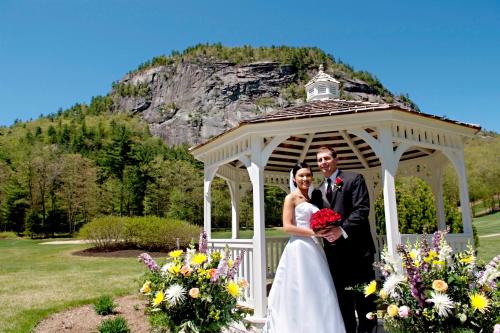 a bride and groom standing in a gazebo at White Mountain Hotel and Resort in North Conway