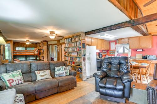 a living room with a couch and a kitchen at Lakefront New Concord Paradise with Screened Porch! in Faxon