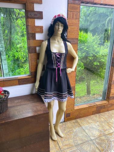 a mannequin in a black dress standing in front of a window at Pousada Tia Moni in Blumenau