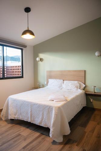a bedroom with a large bed with white sheets at Casa Lomas in Oaxaca City