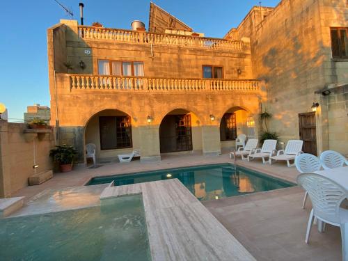 a courtyard with a swimming pool in front of a building at Villa Serenita in Xagħra
