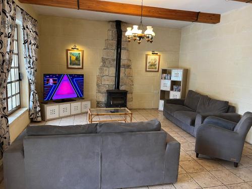 a living room with couches and a flat screen tv at Villa Serenita in Xagħra