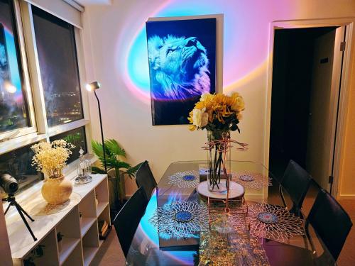 a dining room with a table with a vase of flowers at Eden - Dreamland 伊甸园 - 梦境 in Adelaide