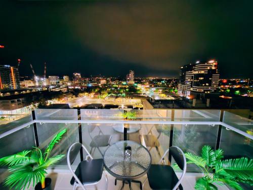 a balcony with a table and chairs and a city at night at Eden - Dreamland 伊甸园 - 梦境 in Adelaide