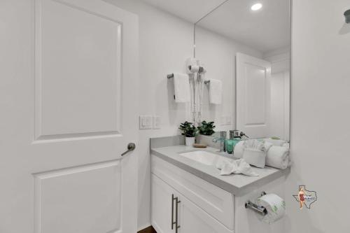 a white bathroom with a sink and a mirror at Bahia Mar Solare Beachfront Resort Condos with Two Pools in South Padre Island