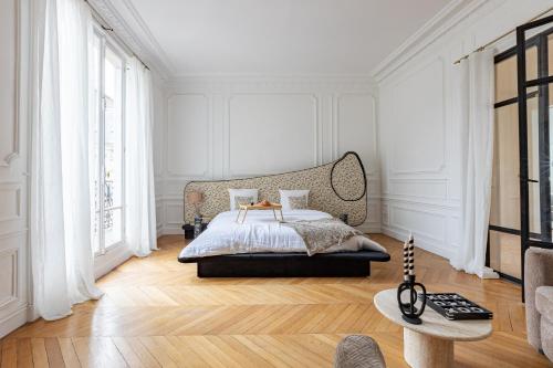 - une chambre blanche avec un lit et un canapé dans l'établissement Luxueux Appartement 4BD, Arc de Triomphe, à Neuilly-sur-Seine