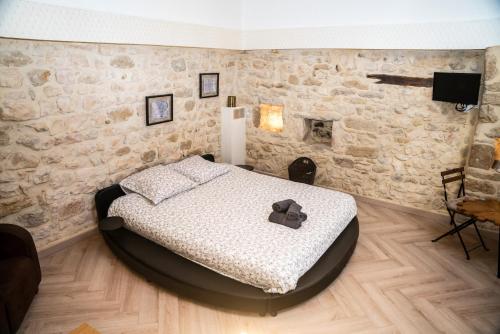 une chambre avec un lit et un mur en pierre dans l'établissement Le Belvédère, à Sauzet