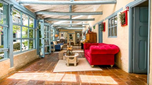a living room with a red couch and windows at Casa Provenzal in Villa de Leyva