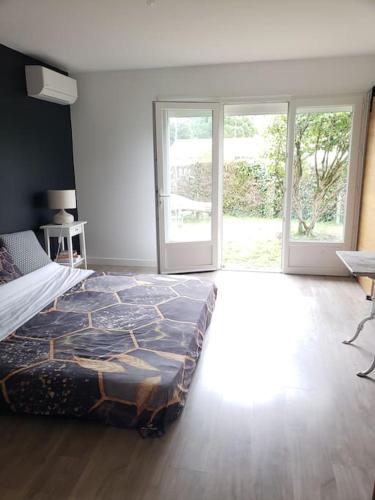 - une chambre avec un grand lit et des portes coulissantes en verre dans l'établissement Agréable maison bien située, à Capbreton