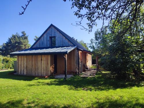 a barn with a gambrel roof on a grass field at TRAFO DOM - Podlesice 74 in Podlesice
