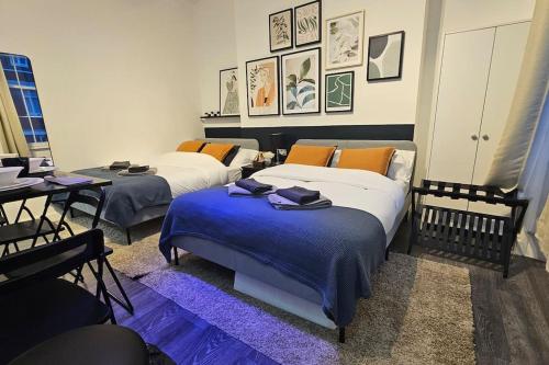 a room with two beds and a table with a table at Beautiful Studios - Chapel Market in London