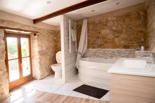 a bathroom with a tub and a sink and a toilet at Le Belvédère in Sauzet