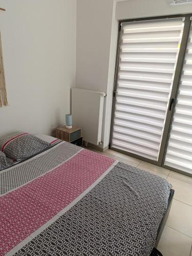 une chambre avec un lit et une grande fenêtre dans l'établissement En bord de mer, à Berck-sur-Mer