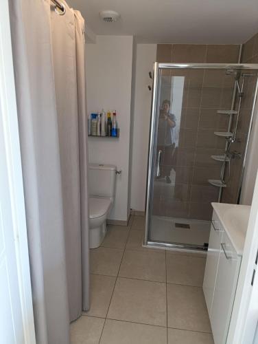 un homme prenant une photo d'une salle de bains avec douche dans l'établissement En bord de mer, à Berck-sur-Mer