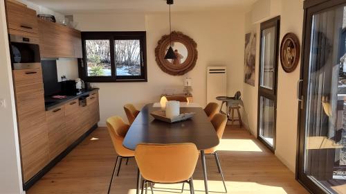 Una cocina y un comedor con mesa y sillas. en FRGK "Élégant Appartement Auron 8 Personnes Vue Imprenable, Terrasse, et Wifi Gratuit", en Auron
