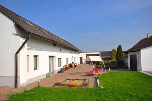a backyard with a play area and a house at Příjemné místo pro odpočinek s bazeném in Radovesice