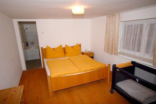 a bedroom with a bed with yellow pillows at Příjemné místo pro odpočinek s bazeném in Radovesice