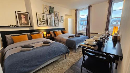 a bedroom with two beds and a desk with a tableasteryasteryasteryasteryastery at Beautiful Studios - Chapel Market in London