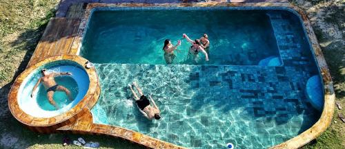 a group of people swimming in a swimming pool at Sítio SPA Céu De Verdade , Praia de Barra Nova , Ceará in Cascavel