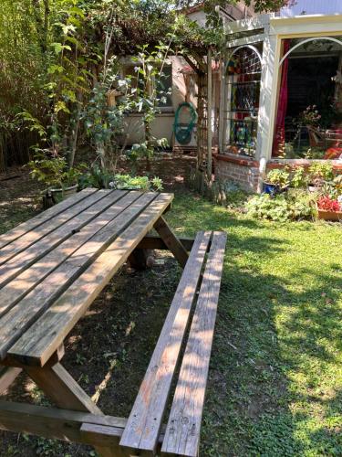 a wooden picnic table sitting in the grass at 2 CHAMBRES B&B PRÈS DE L'AÉROPORT ET DU MEETT in Blagnac