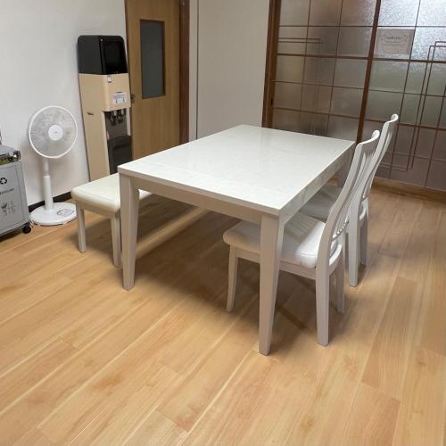 a white table with two chairs and a fan at いろどり荘 ドッグラン併設 露天風呂付き in Inokuchi