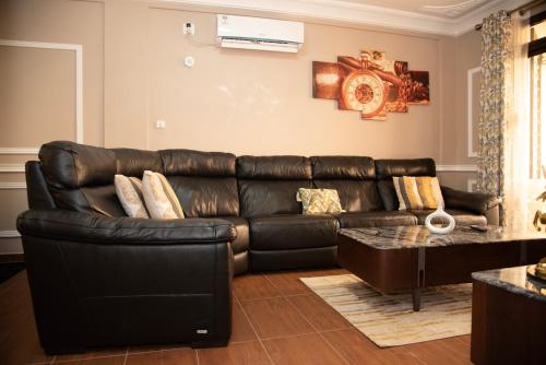 a black leather couch in a living room at Résidence Le Sommet - Appartement VIP in Douala