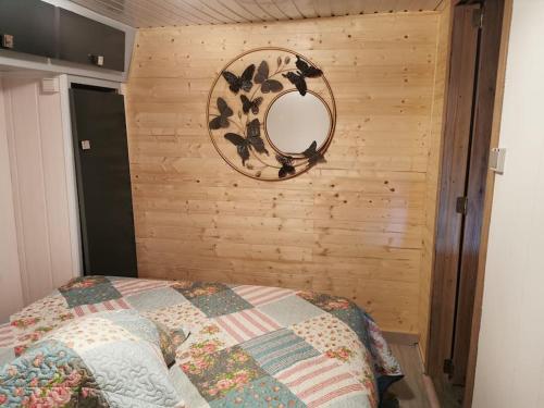 a bedroom with a bed with a mirror on the wall at Chalet Paradise Cottage in Hastière-par-delà