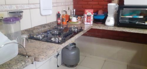 a kitchen with a counter with a stove in it at Chalé jane in Caldas Novas
