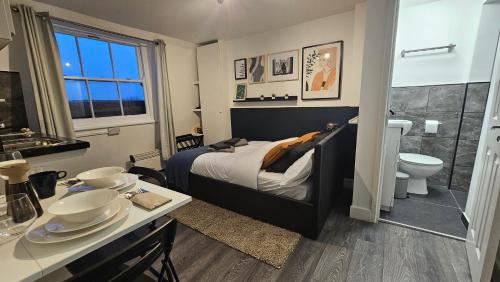a bedroom with a bed and a bathroom with a toilet at Beautiful Studios - Chapel Market in London