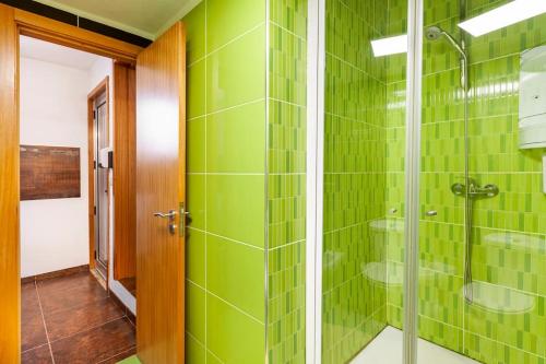 a green tiled bathroom with a walk in shower at Casa do Fontanário in Penafiel