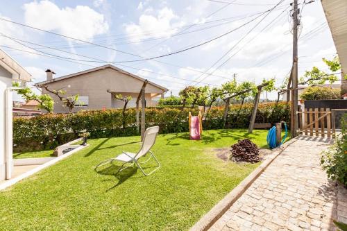 a yard with a chair in the grass at Casa do Fontanário in Penafiel