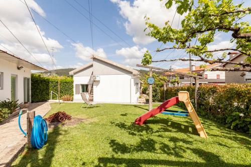 a garden with a playground in the grass at Casa do Fontanário in Penafiel