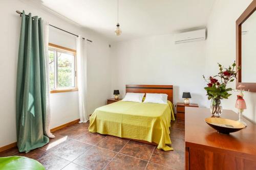 a bedroom with a bed with a yellow blanket at Casa do Fontanário in Penafiel