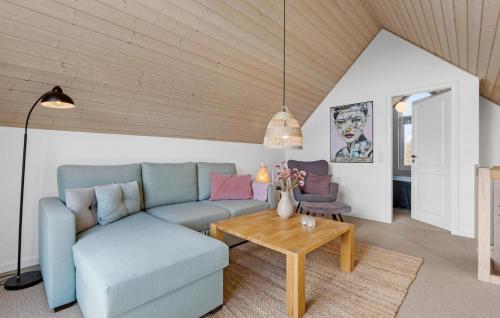 a living room with a blue couch and a table at 2 Bedroom Nice Home In Nørre Nebel in Nørre Nebel